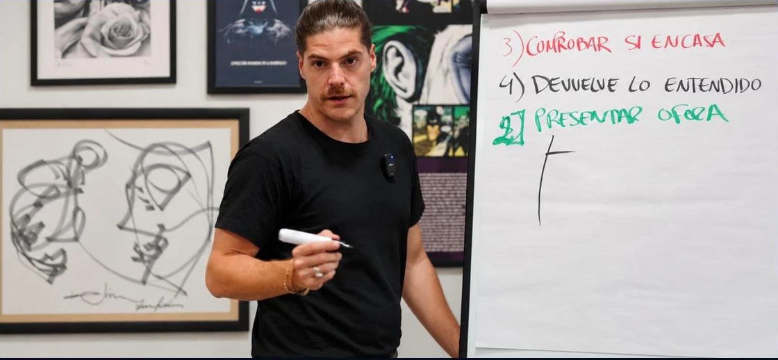 Facilitador del Club durante un taller presencial, junto a una pizarra